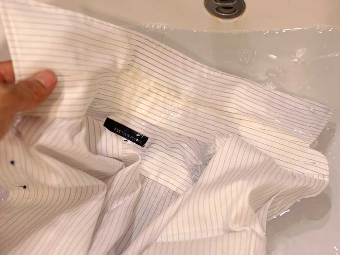 襟が汚れたシャツをぬるま湯に浸す